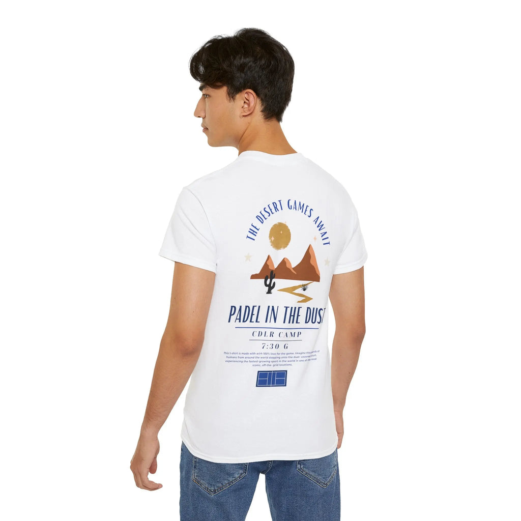 PSF Collective A man stands with his back to the camera, wearing the Printify Limited Edition - Padel in the Dust Tee, featuring a desert scene with cactus, sun, and mountains graphic and the phrase "The desert games await—Padel in the Dust. Designed for the Unwind