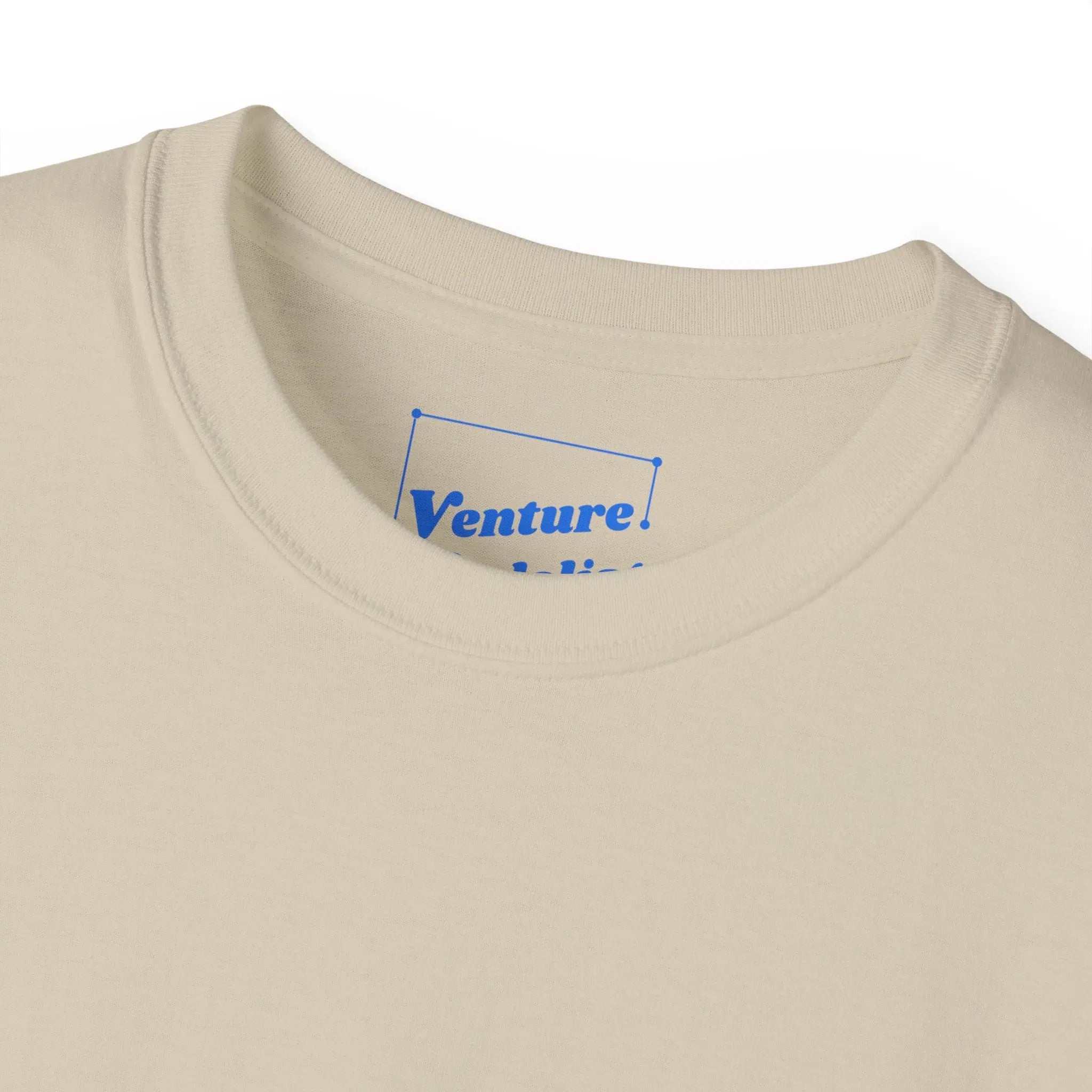 PSF Collective Close-up of the Limited Edition - Padel in the Dust Tee by Printify, a beige crewneck with a blue logo inside the collar. Laid flat on white, it's perfect for fans of unique padel shirts or festival-inspired styles. Designed for the Unwind