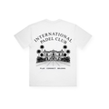 PSF Collective Introducing the Padel Club House Box Tee: crafted in white cotton, this tee showcases an intricate black illustration of a grand building with palm trees. The centered graphic on the upper back features "INTERNATIONAL PADEL CLUB" above and "PLAY. CONNECT. BELONG." below, combining style with sustainability in one statement piece. Designed for the Unwind