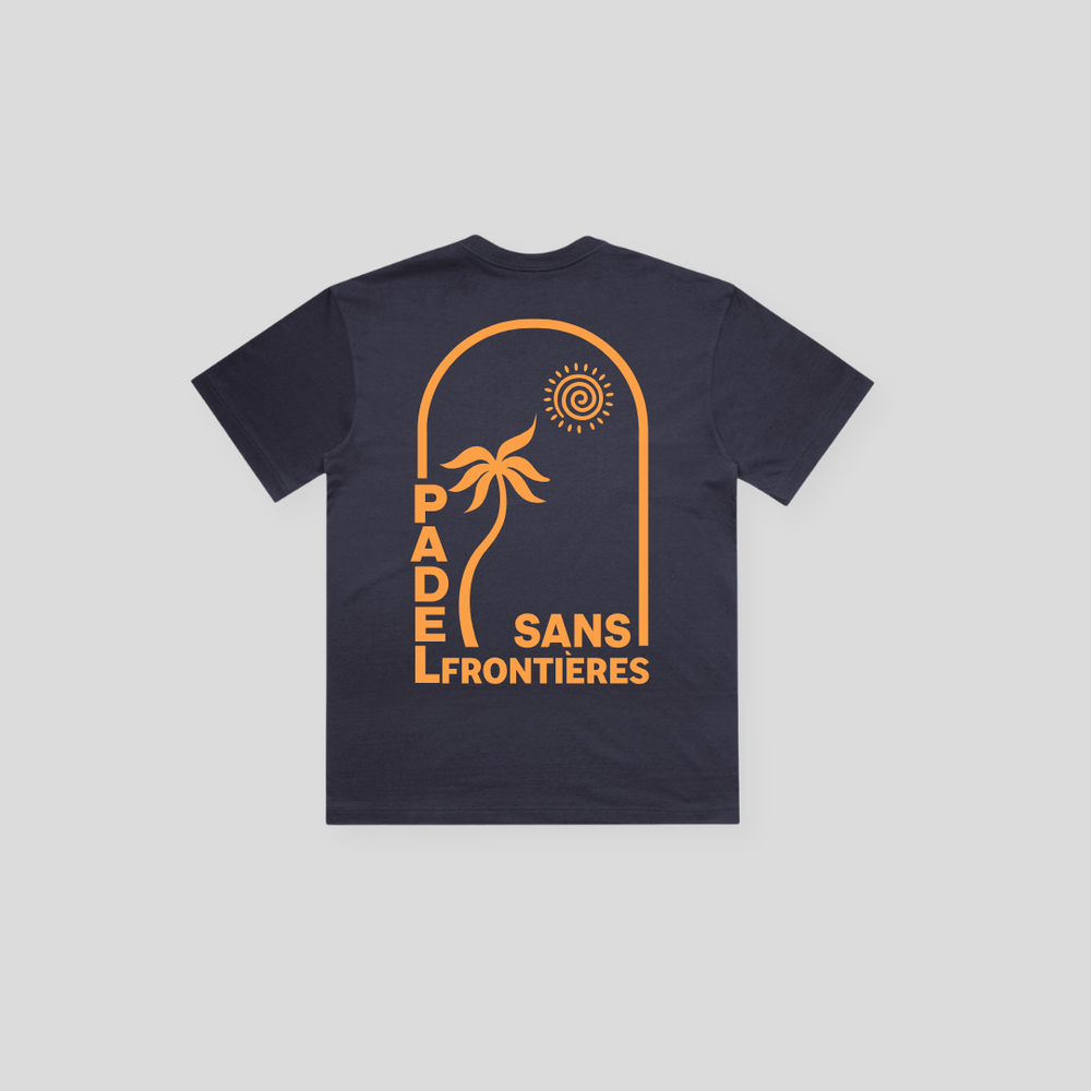 PSF Collective The Sun Arch in Orange Box Tee is a navy blue beach-style t-shirt with a bold orange retro back graphic featuring a palm tree, abstract sun, and arched "PADEL SANS FRONTIERES" text. Designed for the Unwind