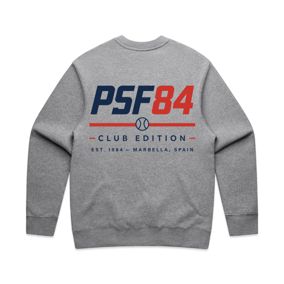 PSF Collective The Padel '84 Sweatshirt features a gray crewneck design with a bold navy blue PSF84, a striking red 84, and a baseball icon on the back. Below these details, CLUB EDITION appears above a red line, with EST. 1984 – MARBELLA, SPAIN printed underneath in smaller blue text. Inspired by vintage sportswear, this sweatshirt combines classic style with sporty padel flair. Designed for the Unwind