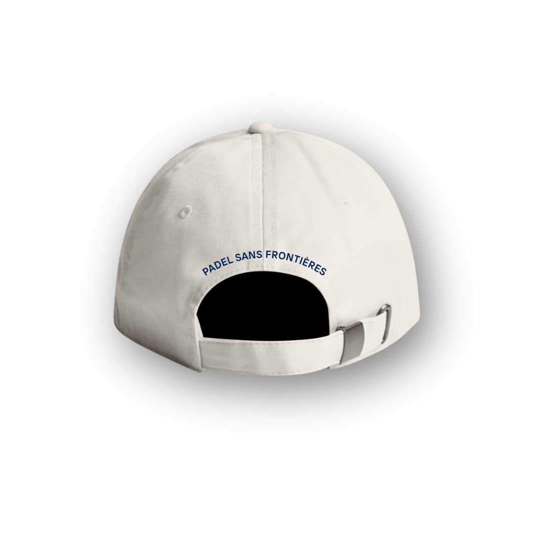 PSF Collective The Heritage Cap in Off White is shown from the back, featuring a fabric strap with a metal clasp. Above the opening, “PADEL SANS FRONTIÈRES” is embroidered in dark blue text. Evoking classic vintage sportswear style, this cap is displayed on a white background with a soft shadow. Designed for the Unwind