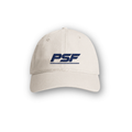 PSF Collective The Retro Cap is a beige hat with PSF embroidered in bold, dark blue letters on the front. It features visible stitching along the brim and two small ventilation holes on each side, capturing the essence of classic 80s sportswear. The cap is showcased against a plain white background with a soft shadow beneath it. Designed for the Unwind
