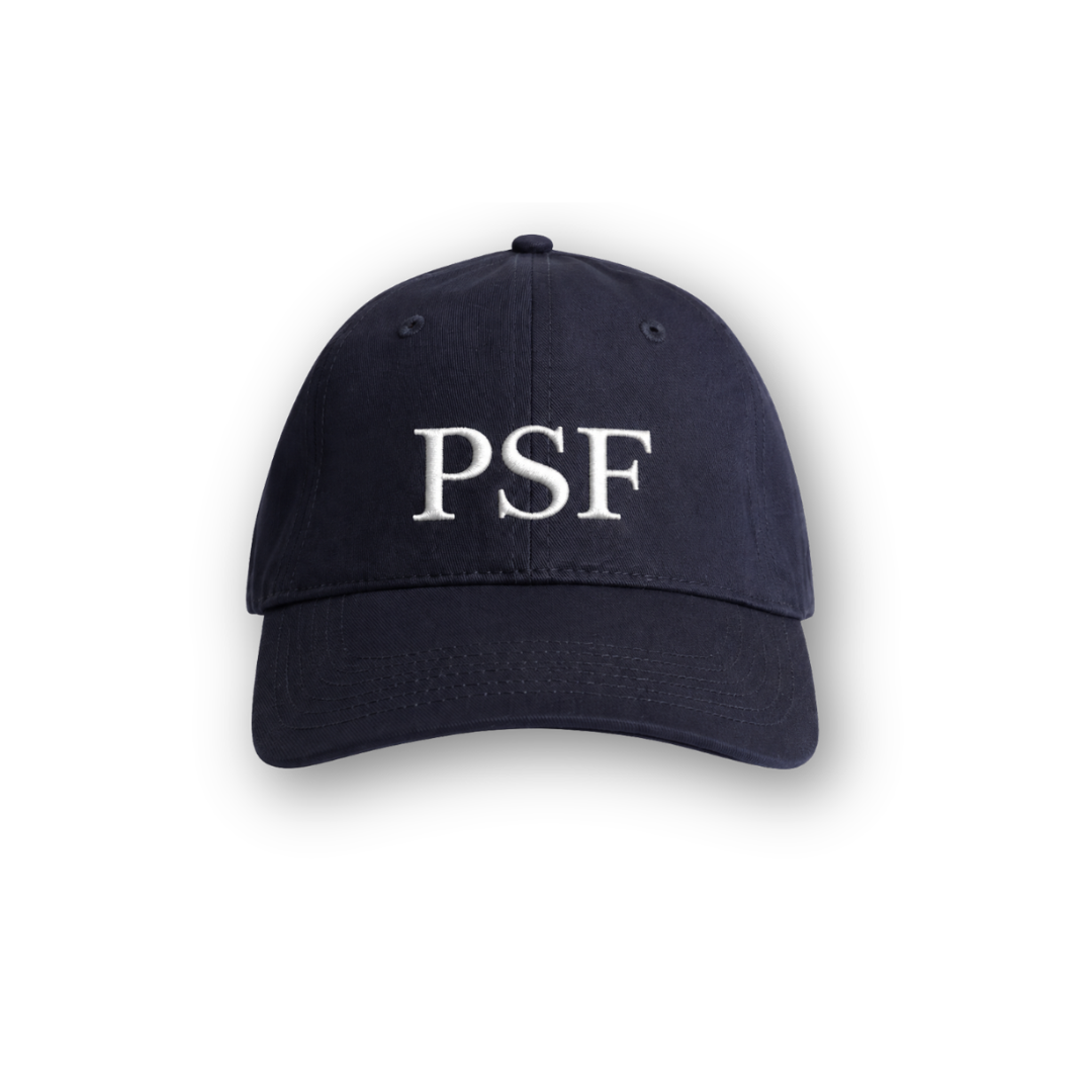 PSF Collective The Classic Cap is a unisex navy tennis hat with “PSF” embroidered in large, white capital letters on the front. Shown from the front against a white background, it features a curved brim and visible stitching details for a timeless retro look. Designed for the Unwind