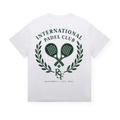 PSF Collective The International Crest Tee1 is a white t-shirt with a green graphic on the back, displaying two crossed padel rackets framed by a heritage crest laurel wreath. The design includes the text “INTERNATIONAL PADEL CLUB,” the PSF company logo, and “MALLORCA · EST. 2024” beneath. Designed for the Unwind