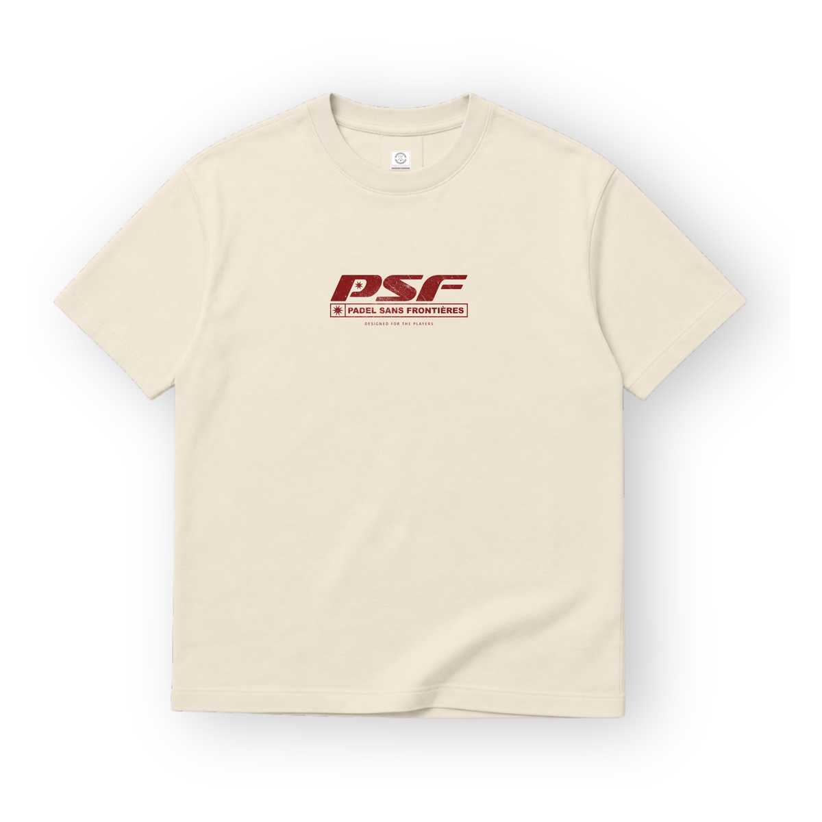 PSF Collective A cream-colored short-sleeved PSF-109 padel t-shirt is centered against a white background, featuring a dark red logo on the chest reading PSF with PADEL SANS FRONTIÈRES and DESIGNED FOR THE PLAYERS printed in a rectangular frame underneath. Designed for the Unwind