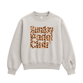 PSF Collective A beige PSF-128 crewneck sweatshirt features the words Sunday Padel Club in a leopard print pattern across the chest, with PSF embroidered in dark brown near the left cuff. Designed for the Unwind